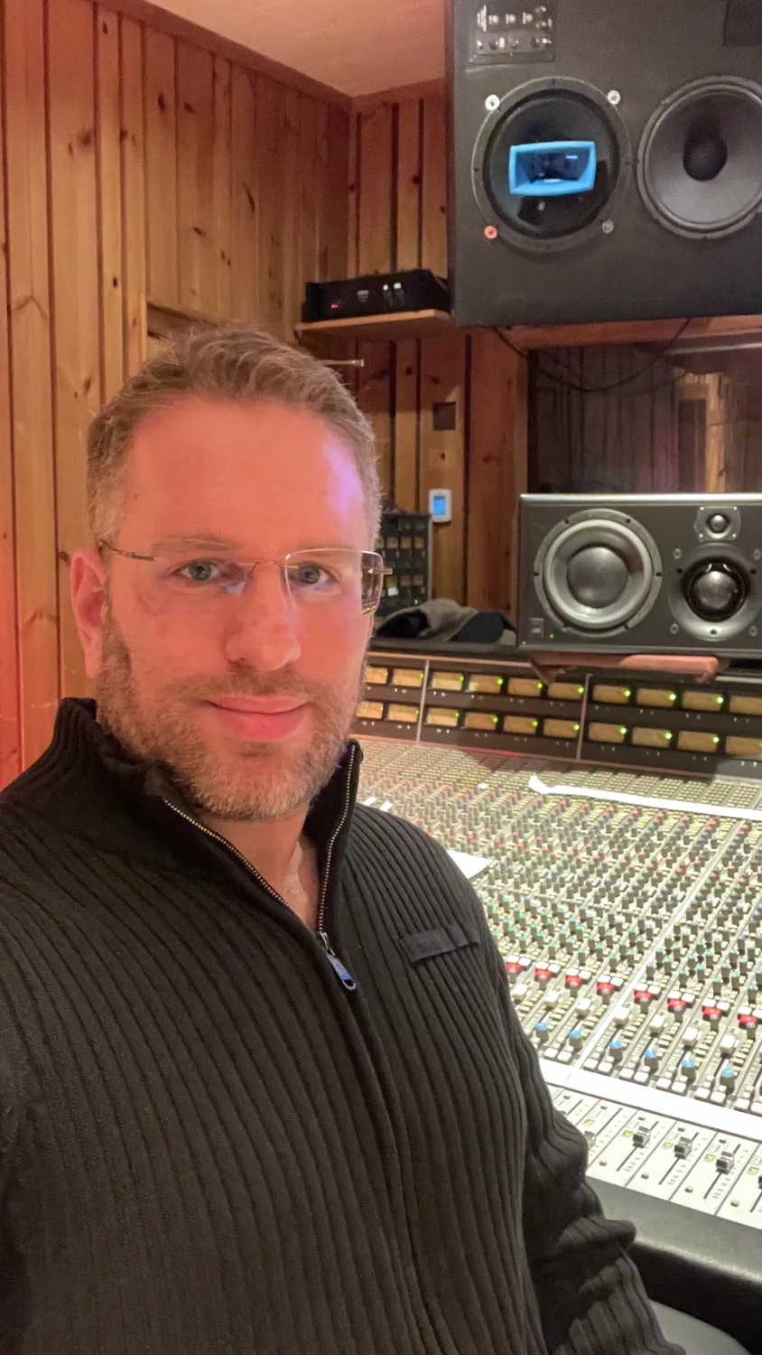 Mor Mezrich at the mixing console in a wood-paneled control room