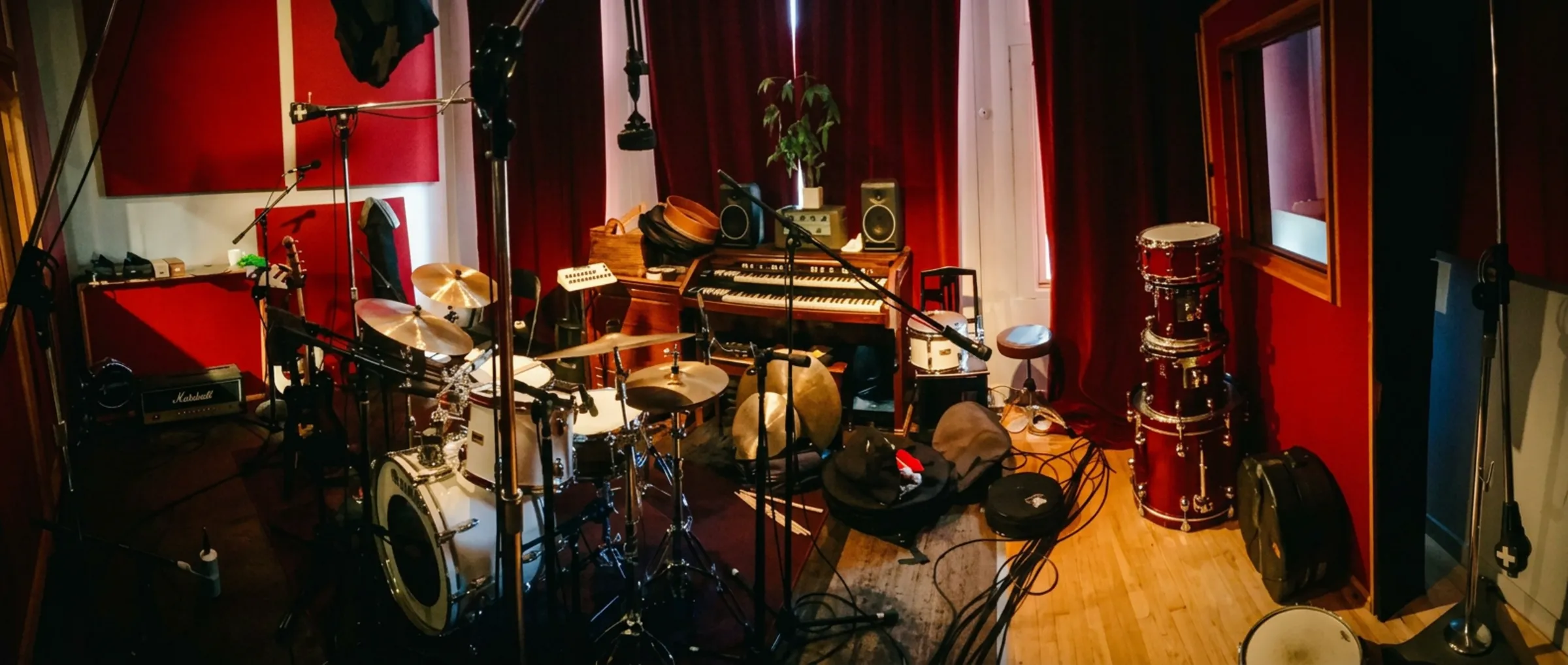 Drum kit set up on a Persian rug in a wood-paneled live room